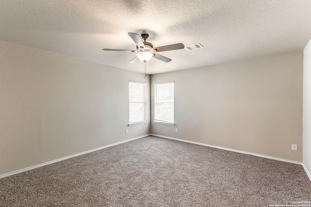 carpeted spare room with a textured ceiling and ceiling fan