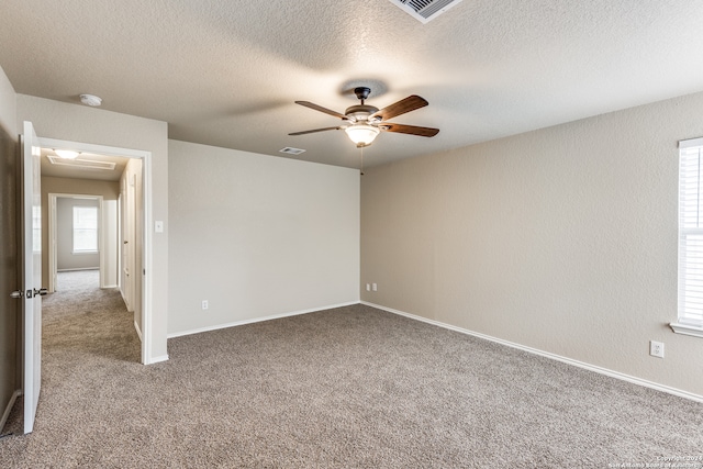 carpeted spare room with a textured ceiling and ceiling fan