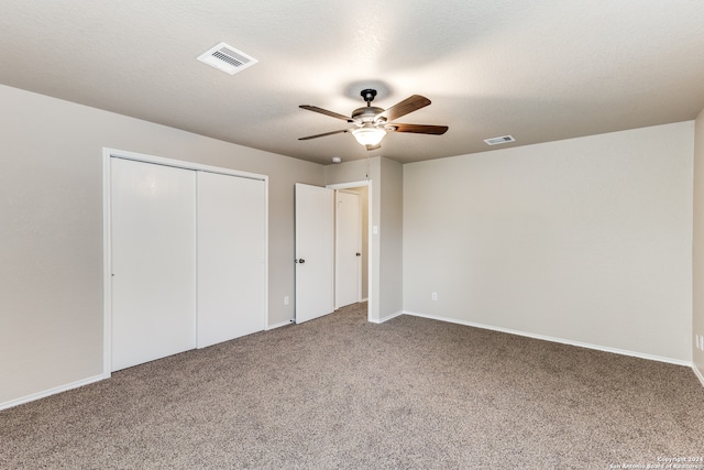 unfurnished bedroom with ceiling fan, carpet flooring, and a closet