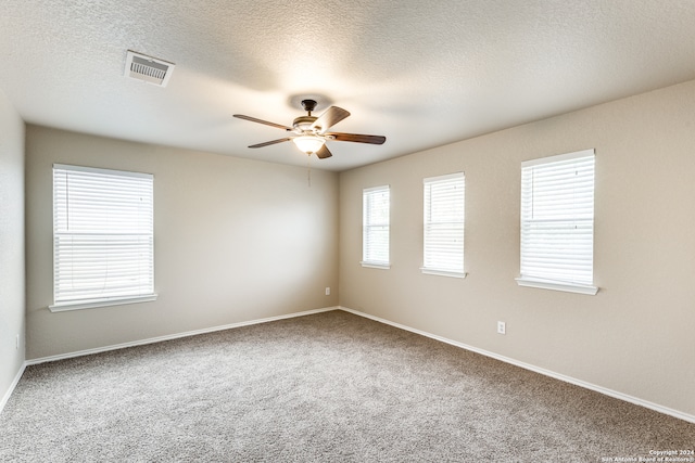 carpeted spare room with ceiling fan and a textured ceiling