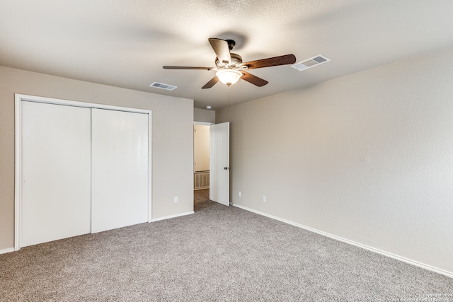 unfurnished bedroom with ceiling fan, a closet, and carpet