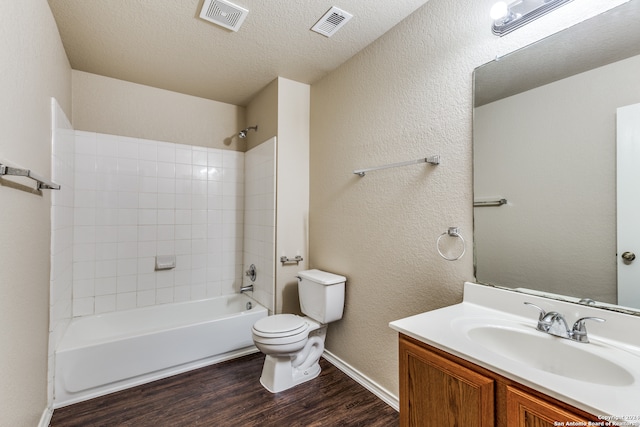 full bathroom with tiled shower / bath combo, toilet, wood-type flooring, oversized vanity, and a textured ceiling