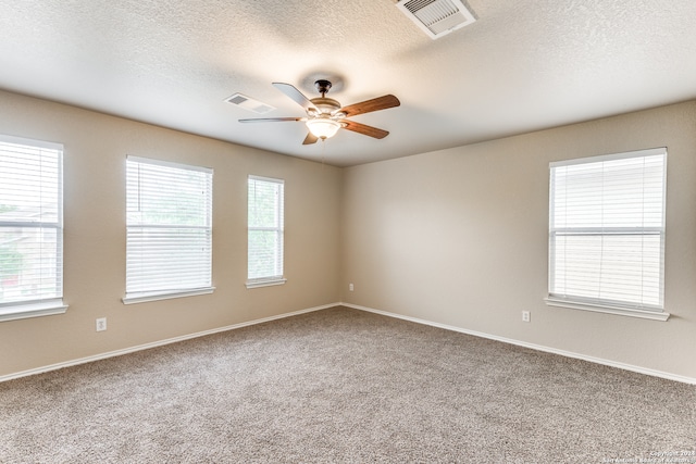 spare room with plenty of natural light, ceiling fan, and light colored carpet