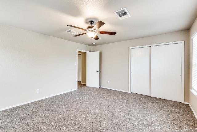 unfurnished bedroom featuring ceiling fan, carpet flooring, and a closet