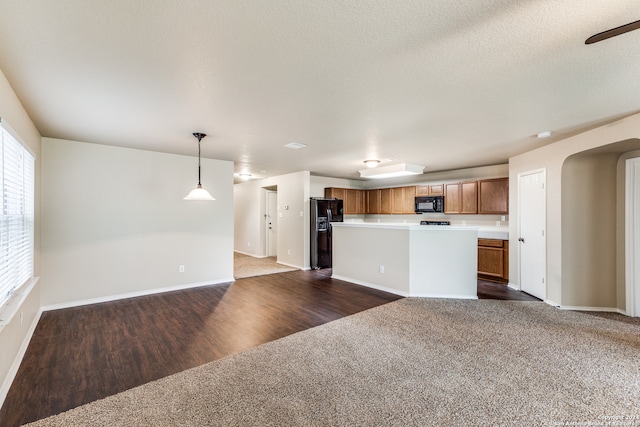 kitchen featuring a kitchen island, dark hardwood / wood-style floors, black appliances, and pendant lighting