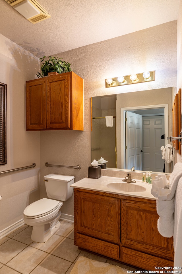 bathroom with toilet, tile floors, a textured ceiling, and oversized vanity