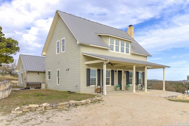 rear view of house featuring ceiling fan and a patio area