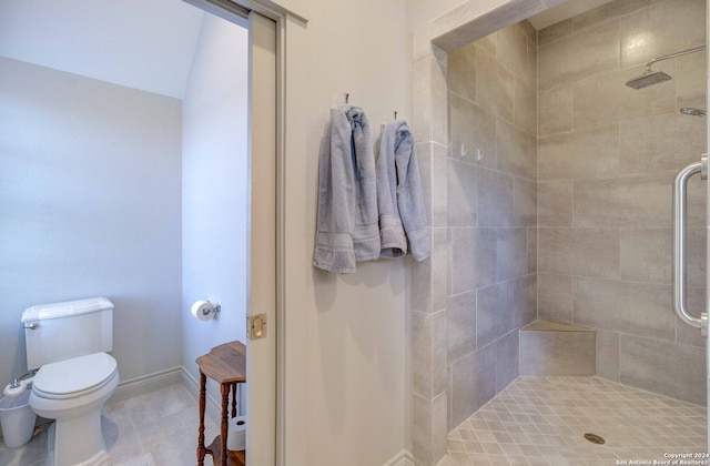 bathroom featuring toilet, tile floors, and a tile shower