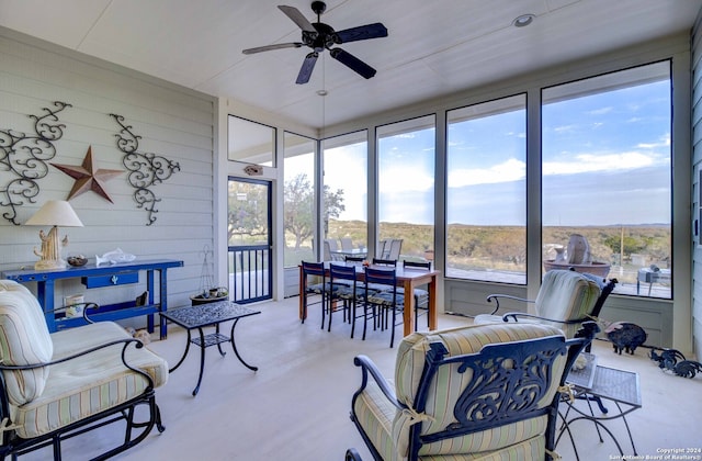 sunroom / solarium with a healthy amount of sunlight and ceiling fan