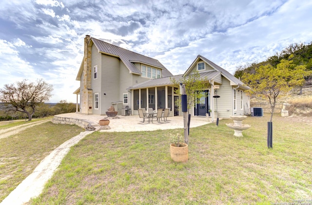 rear view of property featuring central AC, a yard, and a patio