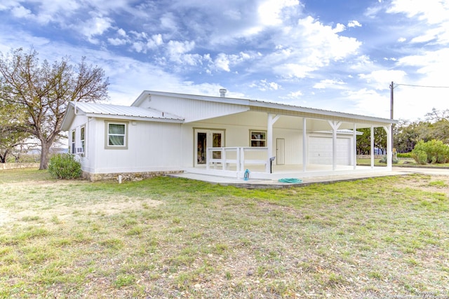 back of property with a garage and a lawn