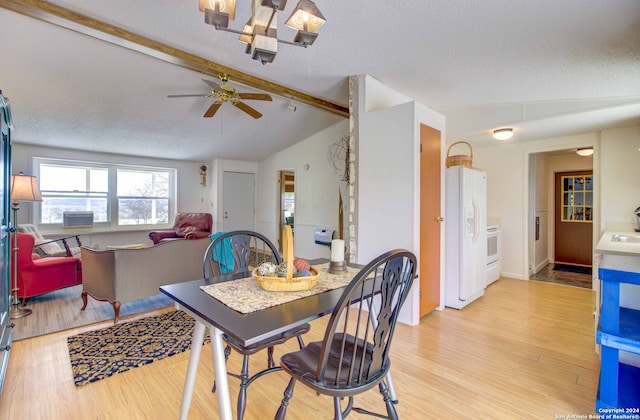 dining area featuring ceiling fan, vaulted ceiling with beams, a textured ceiling, and light wood-type flooring