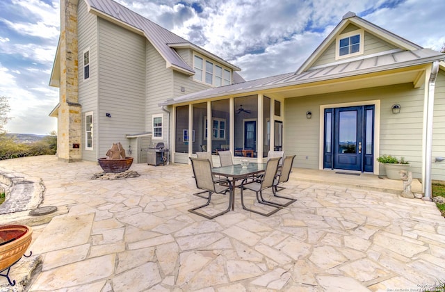 back of property with an outdoor fire pit and a patio