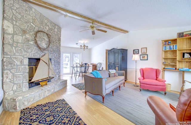 living room with a fireplace, vaulted ceiling with beams, a textured ceiling, and light wood-type flooring