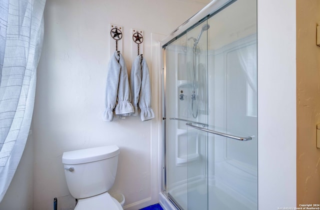 bathroom with toilet and an enclosed shower