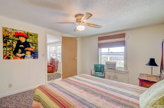 carpeted bedroom with ceiling fan, a textured ceiling, and multiple windows