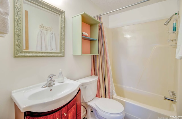 full bathroom with toilet, a textured ceiling, shower / tub combo with curtain, and vanity with extensive cabinet space