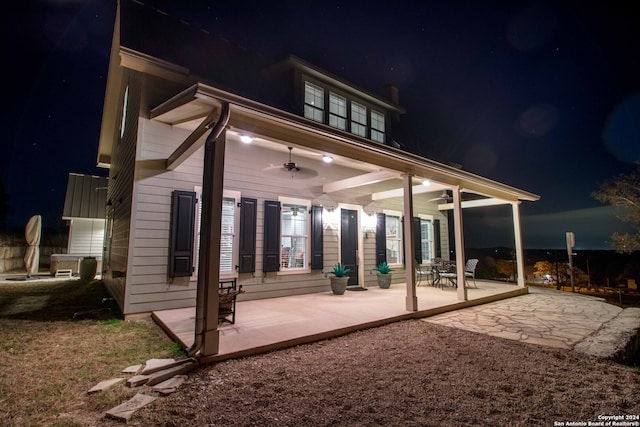 back house at twilight with a patio area and ceiling fan