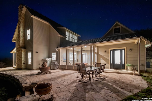 back house at twilight with a patio area