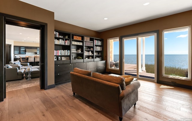 living room featuring a water view and light wood-type flooring