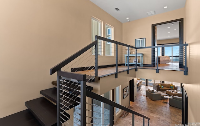 stairs with tile flooring and a high ceiling