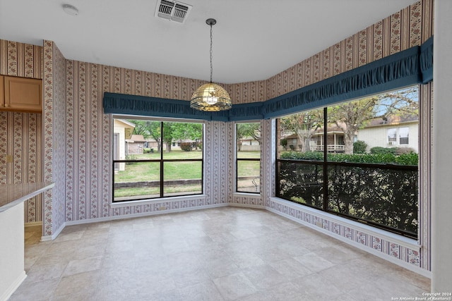 tiled spare room featuring a healthy amount of sunlight