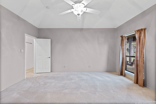 carpeted spare room with ceiling fan and vaulted ceiling