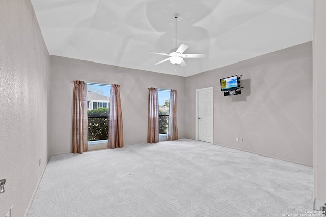 empty room featuring light carpet, vaulted ceiling, and ceiling fan