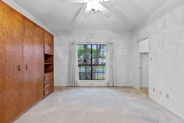 carpeted spare room featuring ceiling fan and lofted ceiling