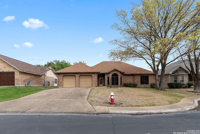 ranch-style home with central air condition unit, a front lawn, and a garage