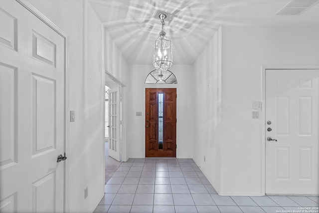 tiled entrance foyer with a chandelier