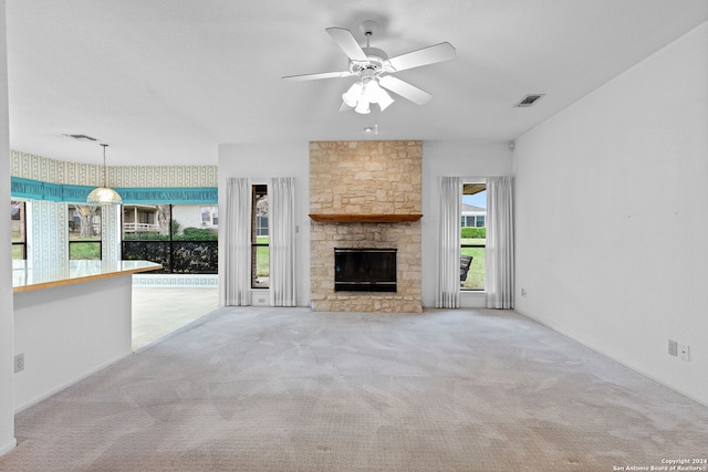 unfurnished living room featuring light carpet, a fireplace, and ceiling fan