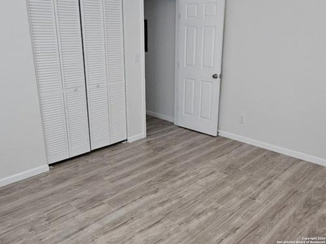 unfurnished bedroom with a closet and light hardwood / wood-style flooring