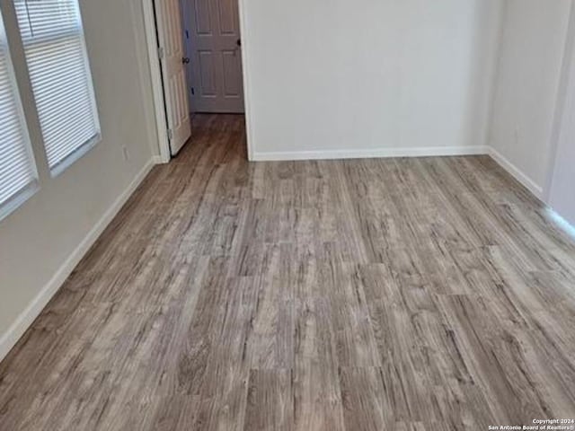 unfurnished bedroom featuring hardwood / wood-style flooring and multiple windows