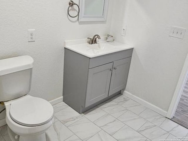 bathroom with tile floors, toilet, and vanity