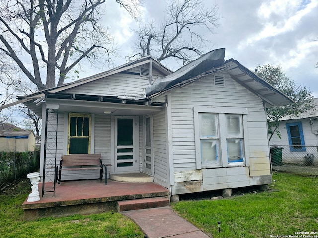 bungalow with a porch and a front lawn