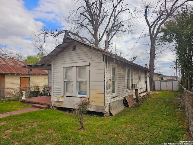 exterior space featuring a wooden deck, a storage shed, and a lawn