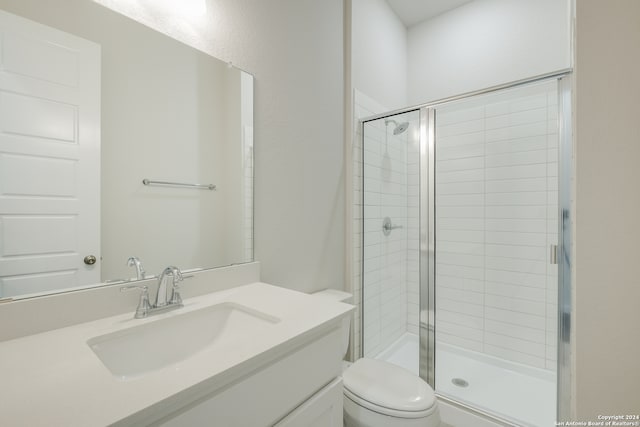 bathroom with a shower with door, toilet, and vanity