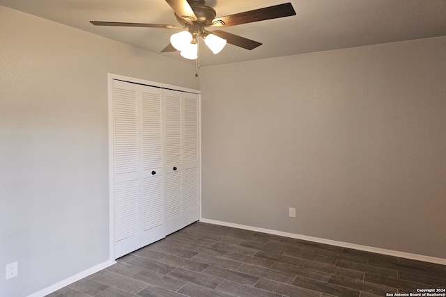 unfurnished bedroom with ceiling fan, a closet, and dark hardwood / wood-style floors