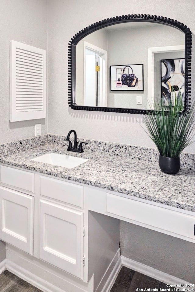 bathroom featuring vanity with extensive cabinet space and hardwood / wood-style flooring