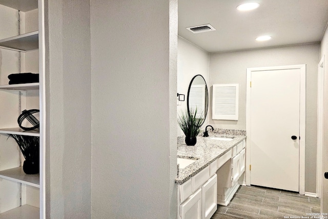 bathroom with double sink, hardwood / wood-style flooring, and oversized vanity