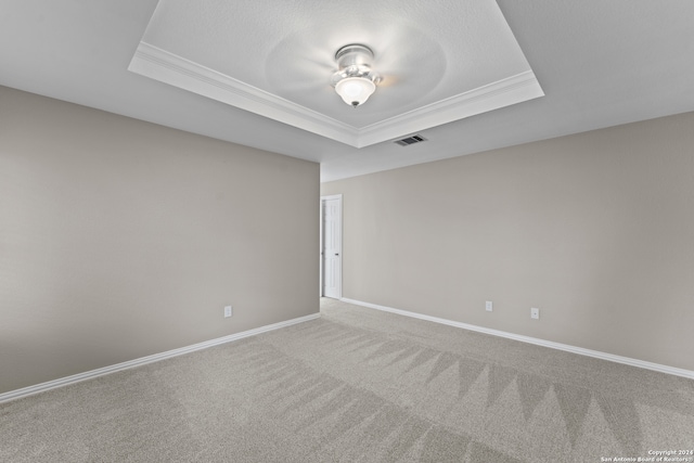 carpeted spare room featuring ornamental molding, a tray ceiling, and ceiling fan