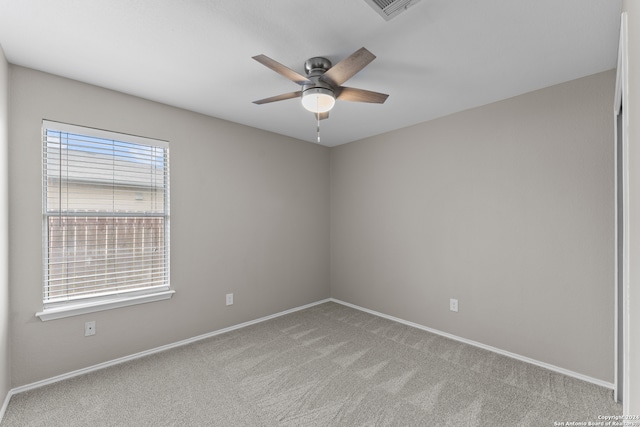 carpeted empty room featuring ceiling fan and plenty of natural light