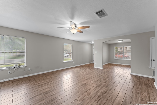 unfurnished room featuring a textured ceiling, wood-type flooring, and ceiling fan