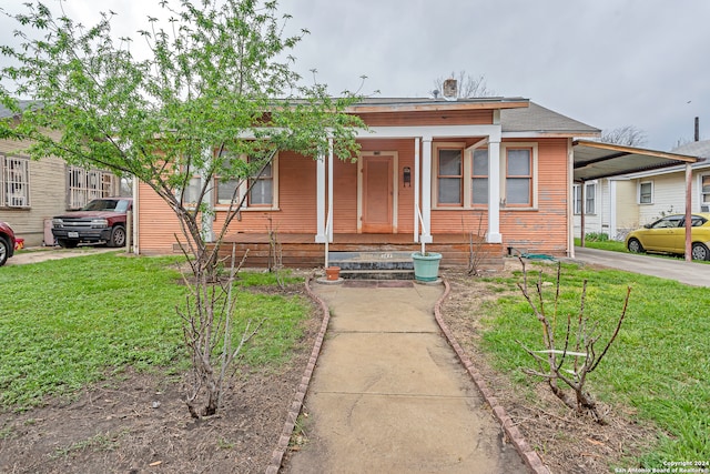 bungalow-style home featuring covered porch and a front lawn