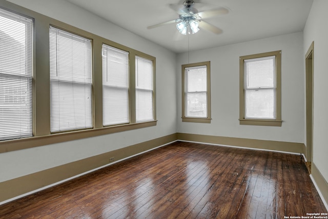 empty room with ceiling fan and dark hardwood / wood-style flooring