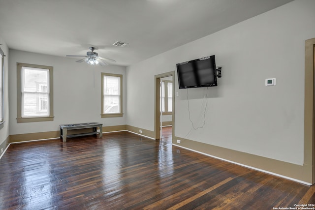 empty room with ceiling fan and dark hardwood / wood-style flooring