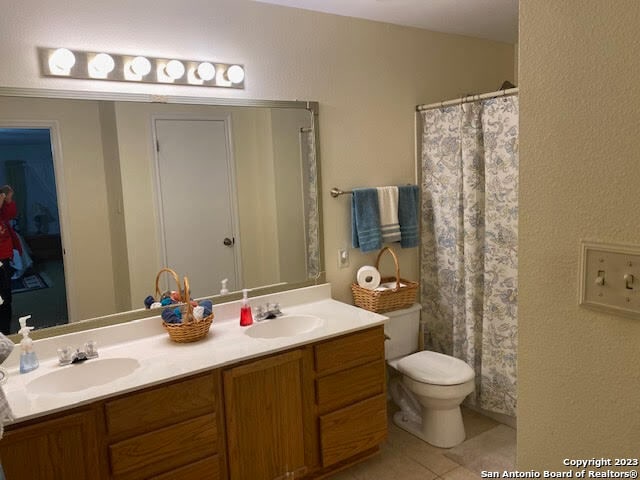 bathroom with toilet, tile patterned flooring, and vanity