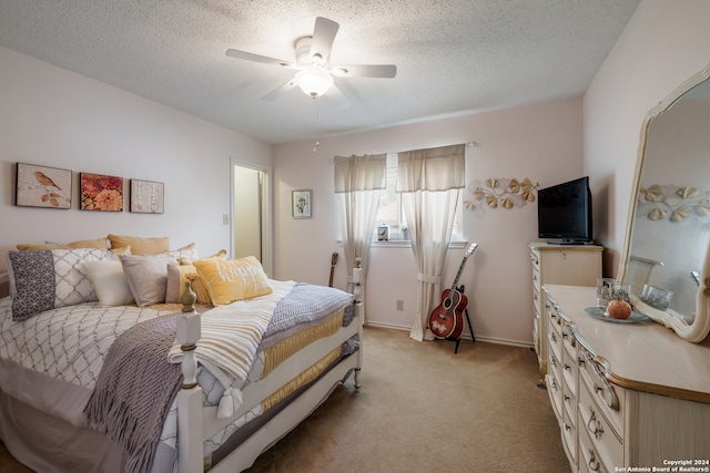 carpeted bedroom with ceiling fan and a textured ceiling