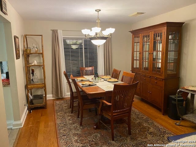 dining space featuring a chandelier and dark hardwood / wood-style flooring